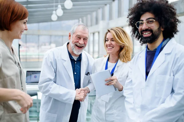 Group of doctors standing in corridor on medical conference. — Stock Photo, Image