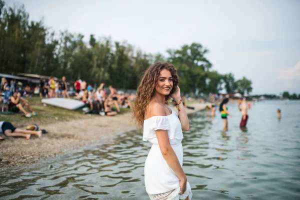 Ung kvinna på sommarfestivalen, stående i sjön. — Stockfoto