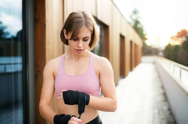 En ung kvinna övar karate utomhus på terrassen. — Stockfoto