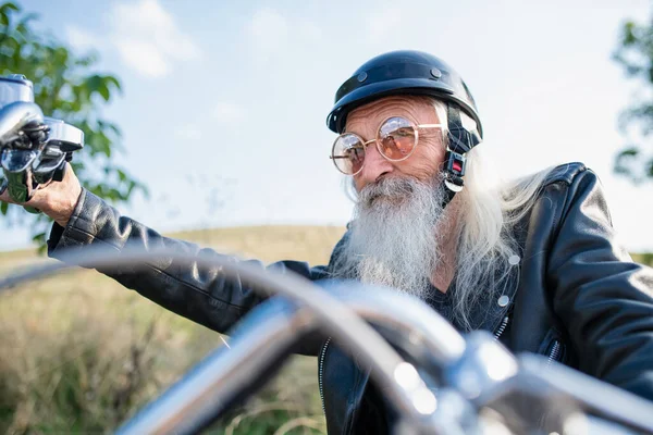 Un voyageur senior avec moto à la campagne . — Photo