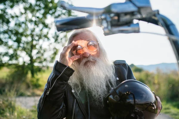 Senior άτομο ταξιδιώτη με μοτοσικλέτα και γυαλιά ηλίου στην ύπαιθρο. — Φωτογραφία Αρχείου