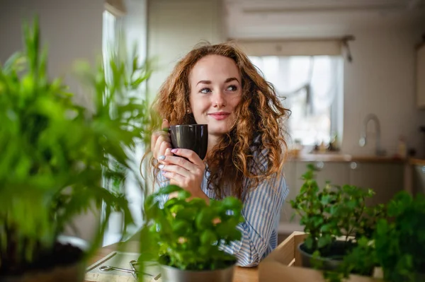 Young woman relaxing indoors at home with cup of coffee or tea. — Zdjęcie stockowe