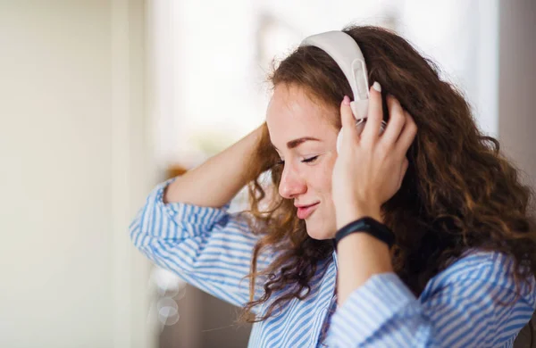 Young woman with headphones relaxing indoors at home. — Stock Photo, Image