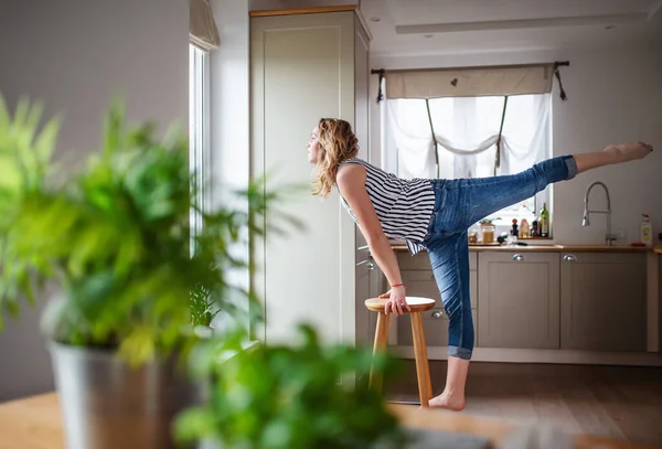 Young woman relaxing indoors at home, stretching. — Stockfoto