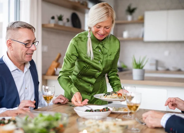 Groupe d'amis seniors au dîner à la maison, manger . — Photo