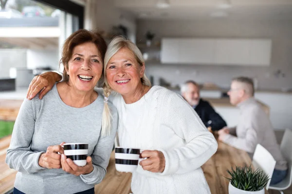 Портрет пожилых женщин-друзей с кофе дома, смотрящих в камеру . — стоковое фото