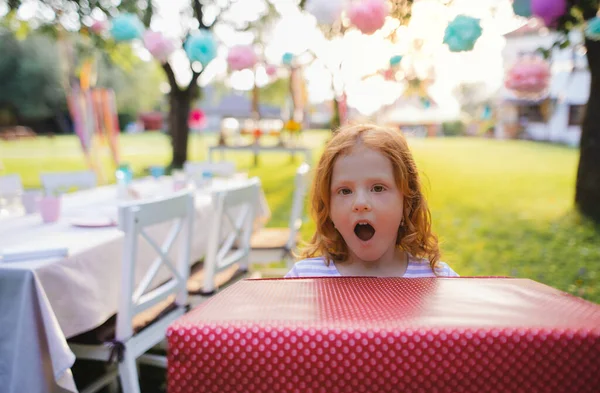 Retrato de niña pequeña con caja de regalo grande al aire libre en el jardín en verano . — Foto de Stock