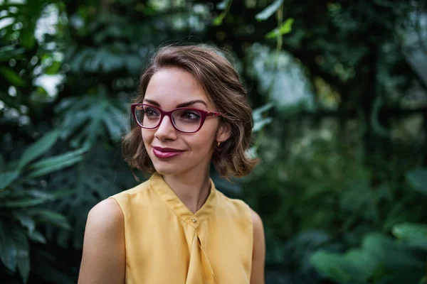 Jovem mulher de pé no jardim botânico. Espaço de cópia . — Fotografia de Stock