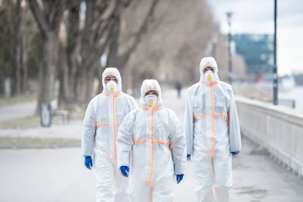 Personas con trajes de protección caminando al aire libre, concepto coronavirus . —  Fotos de Stock