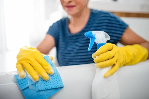 Unerkennbare Seniorin mit Handschuhen putzt zu Hause. — Stockfoto