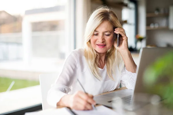 Vezető nő okostelefonnal és laptoppal az otthoni irodában, dolgozik. — Stock Fotó