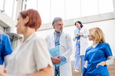 Bir grup doktor tıp konferansında merdivenlerden iniyor..