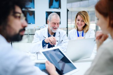 Bir grup doktor tıbbi konferansta röntgene bakıyor, sorunları tartışıyorlar..