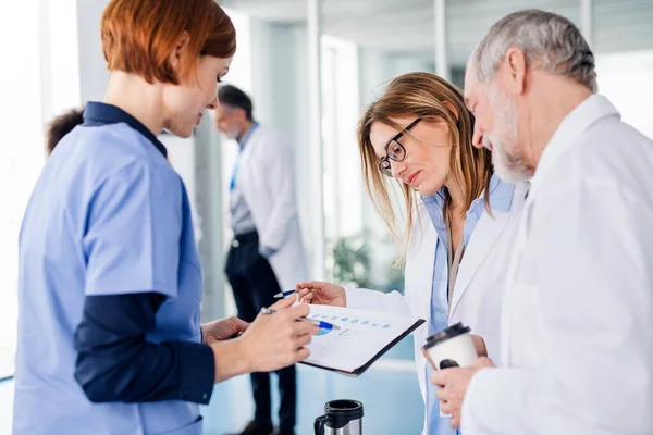 Bir grup doktor konferansta, tıbbi ekip sorunları tartışıyor..