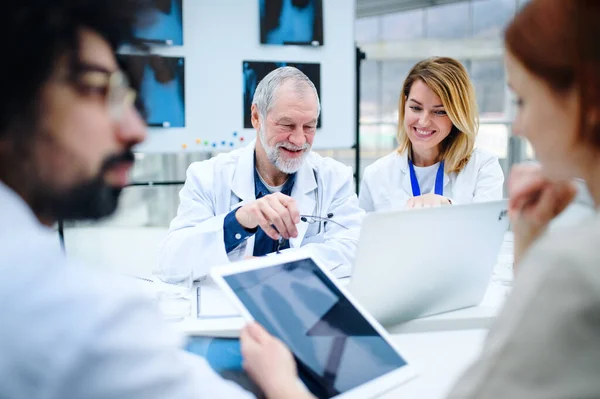 Grupa lekarzy patrzących na rentgen na konferencji medycznej, omawiających kwestie. — Zdjęcie stockowe