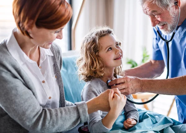 Dokter onderzoekt een klein ziekenhuis meisje met moeder in het ziekenhuis. — Stockfoto