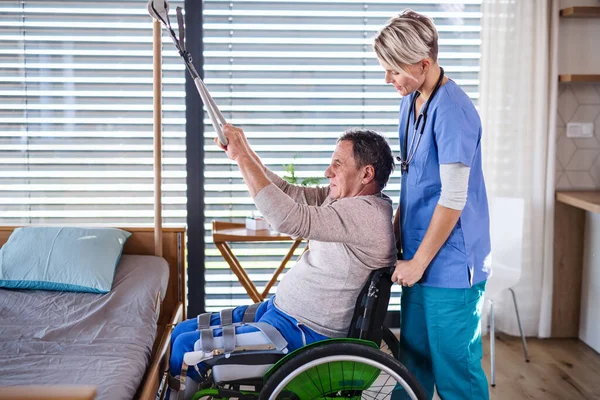 Pracownik służby zdrowia i starszy pacjent na wózku inwalidzkim, fizjoterapia. — Zdjęcie stockowe