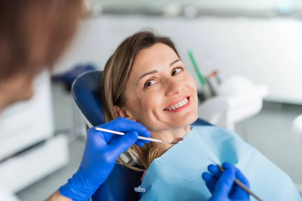 歯医者の手術で歯医者さんの診察を受けている女性が. — ストック写真