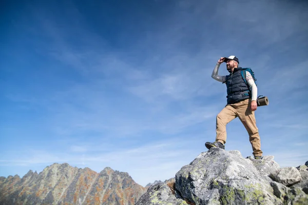 Homem maduro com mochila caminhadas nas montanhas no verão . — Fotografia de Stock