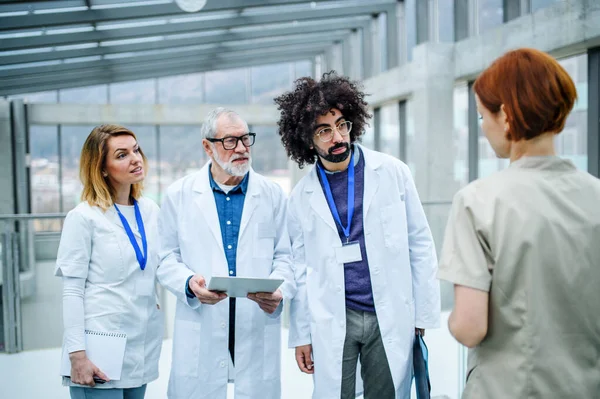 Groupe de médecins avec tablette sur conférence, équipe médicale parlant . — Photo