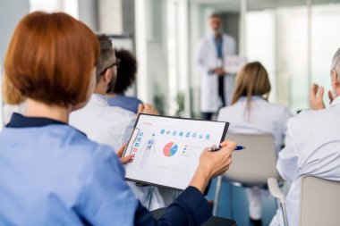 Konferansa katılan bir grup doktor, oturup dinleyen tıbbi ekip..