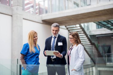 Group of doctors talking to pharmaceutical sales representative.