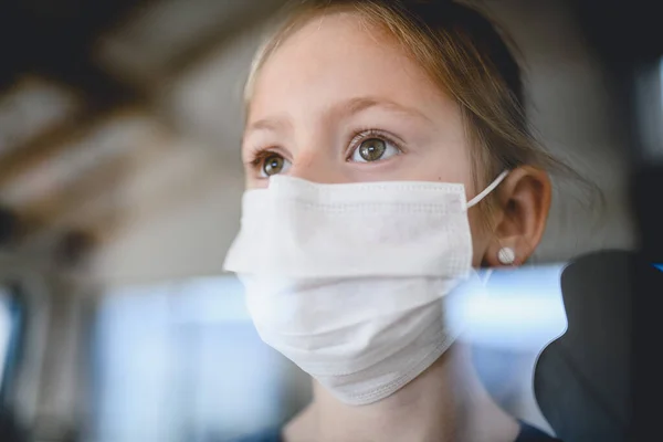 집안에 마스크를 쓰고 있는 작은 소녀, 코로나 바이러스와 격리 개념. — 스톡 사진