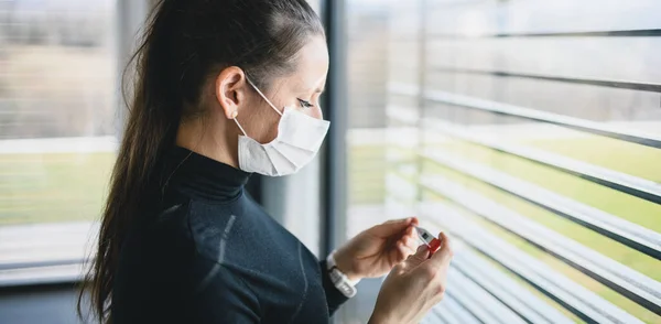 Bezorgde vrouw met thermometer en gezichtsmaskers binnen thuis, Corona virus concept. — Stockfoto