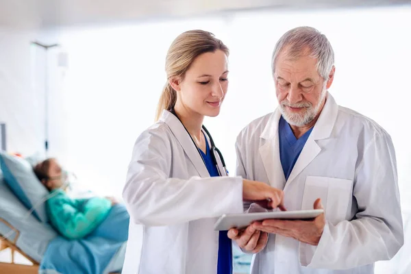 Läkare med tablett talar på sjukhus, coronavirus koncept. — Stockfoto