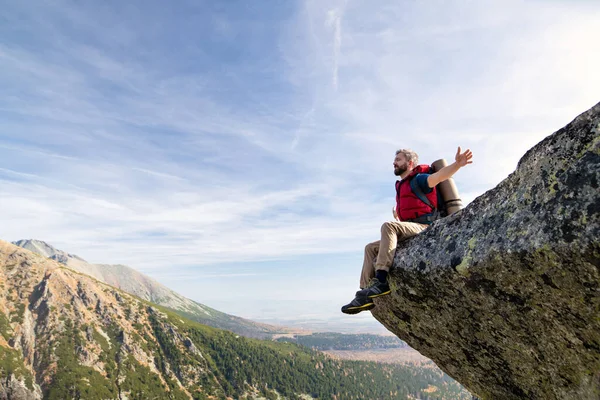 Reifer Mann mit Rucksack wandert im Herbst in den Bergen, ruht sich aus. — Stockfoto