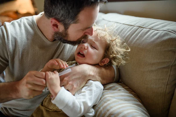 Padre con una pequeña hija enferma llorando en casa . —  Fotos de Stock