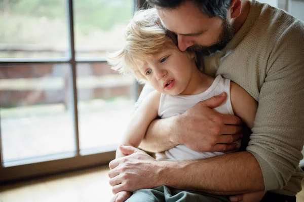 Pai com pequeno filho infeliz doente dentro de casa, confortando-o . — Fotografia de Stock