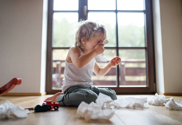 Pequeño niño enfermo con frío en casa sentado en el suelo, estornudando . —  Fotos de Stock