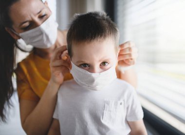 Evde maskeli anne ve çocuk, Corona virüsü ve karantina konsepti..