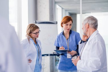 Bir grup doktor konferansta, tıbbi ekip sorunları tartışıyor..