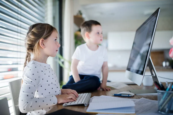 Klein meisje en jongen die thuis computer gebruiken. Corona-virus en quarantaineconcept. — Stockfoto