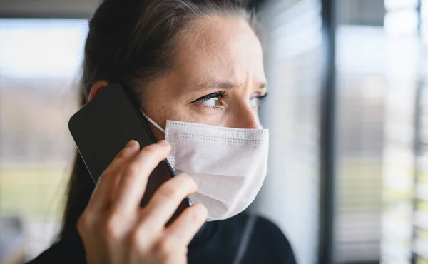 Ustaraná žena s telefonem a obličejovými maskami doma, koncepce viru Corona. — Stock fotografie