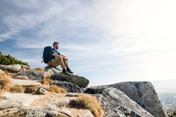 Gammal man med ryggsäck vandring i bergen på hösten, vila. — Stockfoto