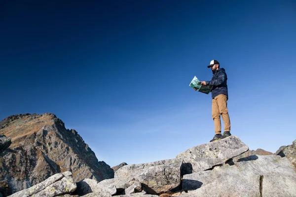 Yazın dağlarda yürüyüş yapan olgun bir adam, harita kullanarak.. — Stok fotoğraf