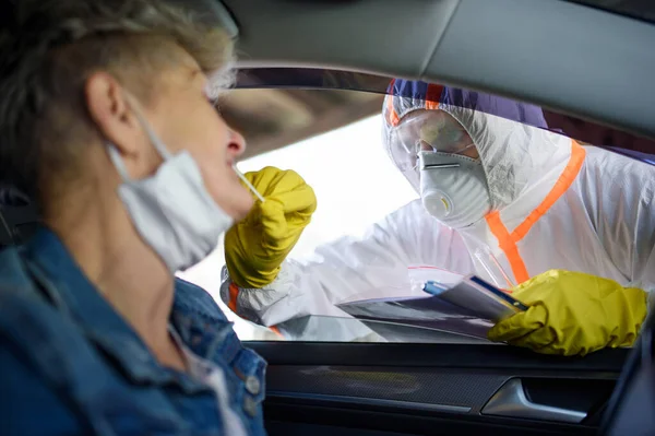 Koronavírus teszt minta idősebb nő az autóban, karantén koncepció. — Stock Fotó