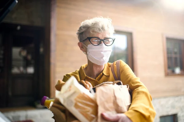 Seniorin mit Gesichtsmaske im Freien mit Einkauf, Coronavirus und Quarantäne-Konzept. — Stockfoto