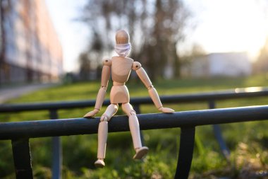 Yüzü maskeli tahta manken, korona virüsü ve tecrit konsepti..