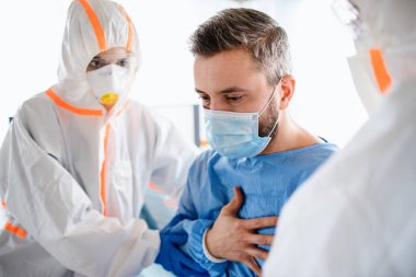 Doktorlar ve enfekte hasta hastanede karantinada, koronavirüs konsepti.