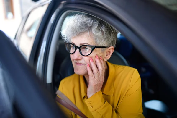 Senior kvinna med glasögon kliva ur en bil. — Stockfoto