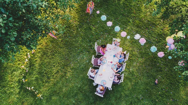 Luftaufnahme von kleinen Kindern, die auf Sommerfest am Tisch sitzen. — Stockfoto