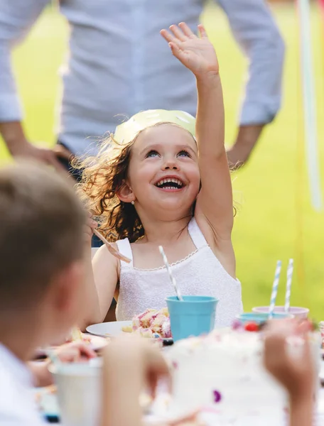 Glad liten flicka firar födelsedag utomhus i trädgården på sommaren, fest koncept. — Stockfoto