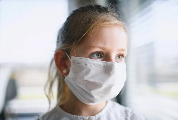 Niña con mascarillas en casa, virus Corona y concepto de cuarentena . — Foto de Stock