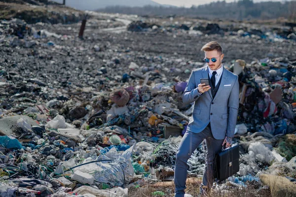 Homme d'affaires moderne sur la décharge, le consumérisme versus concept de pollution . — Photo