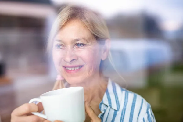 Retrato de mulher idosa com xícara de café em casa . — Fotografia de Stock