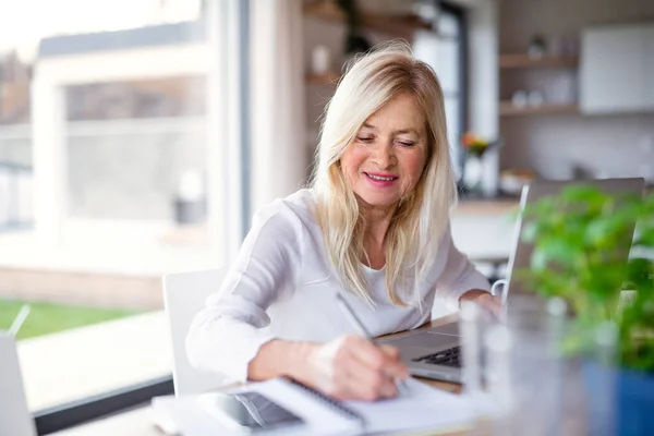 Femme âgée avec ordinateur portable à l'intérieur dans le bureau à la maison, travaillant . — Photo